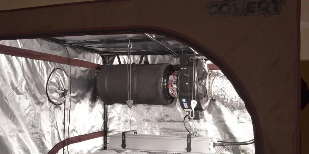 Inline fan connected to carbon filter and ducting in a grow tent setup